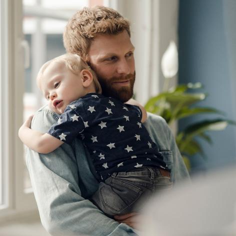 Mann hält Kleinkind